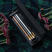 Load image into Gallery viewer, Set of Blackwing pencils in a black case on a plaid fabric background with flowers.