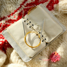 Load image into Gallery viewer, Knitting needles in a small beige case on a knitted fabric background