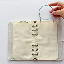 Load image into Gallery viewer, Handmade fabric pouch with metal clasps held by a hand on a white background