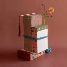 Load image into Gallery viewer, Stack of books with decorative ribbons and a tassel on a brown background