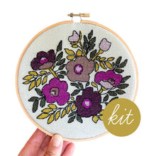 Load image into Gallery viewer, Embroidery hoop with floral design held by a hand, labeled 'kit' on a white background