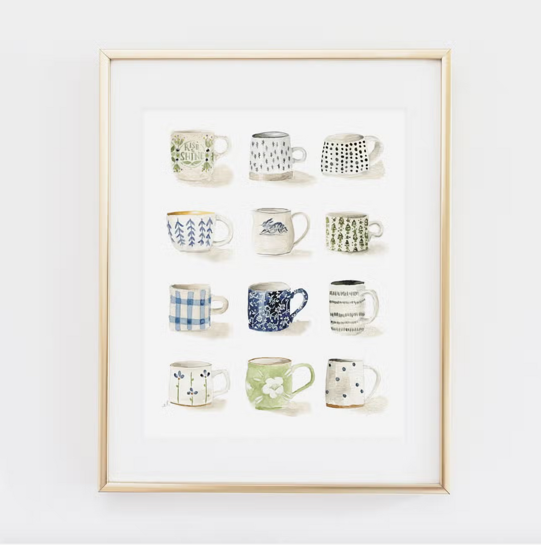 Gold colored frame around white print with mugs in four lines of three along it on white background. Mugs are various shades of blue, green and gray and feature images of flowers, polka dots, trees, etc.