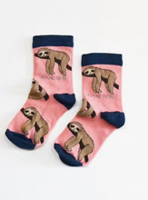 Load image into Gallery viewer, Pink socks with navy blue cuffs, heels and toes. Tan sloths on branches line the socks. The name Bare Kind is written in light grey under the first row of sloths.