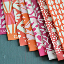 Load image into Gallery viewer, Set of colorful patterned paper strips on a dark surface