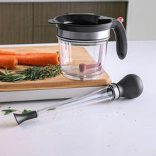 Load image into Gallery viewer, Baster on counter next to a measuring pot and carrots on a cutting board.