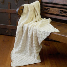 Load image into Gallery viewer, White knitted blanket lays over side of wooden bench 